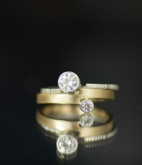 vis a vis moissanites bezel set in platinum and mixed metals asymmetrical engagement ring with textured wedding band