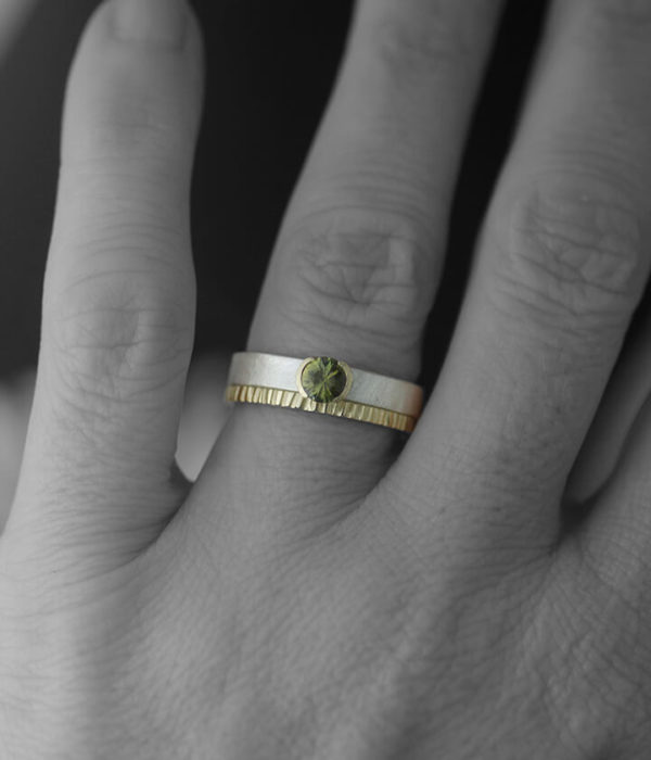 green sapphire with flat crenelated band on hand