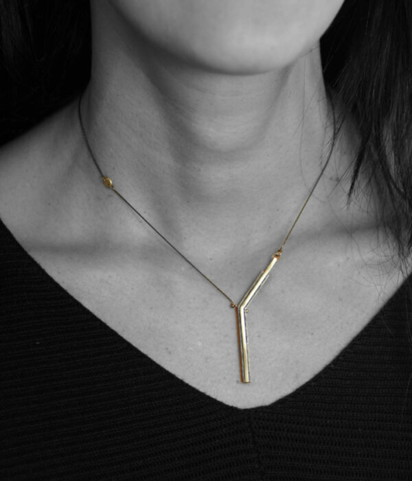 half y necklace on model