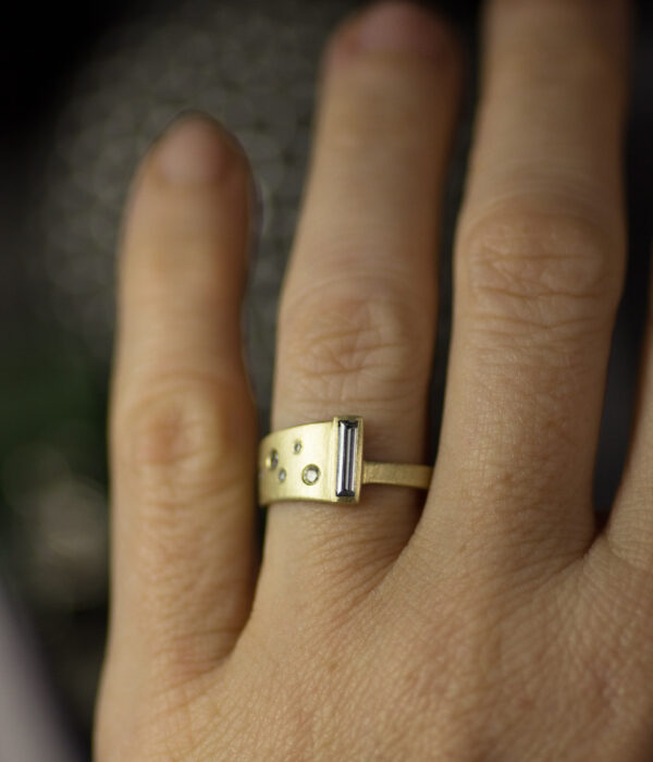 assymmetrial salt and pepper diamond wrap 14K yellow gold alt engagement ring with grey moissanite baguette on hand scaled