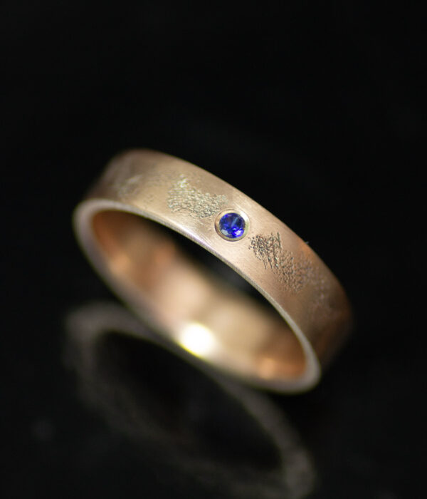 14K rose gold interstellar gender neutral wedding band with blue sapphire